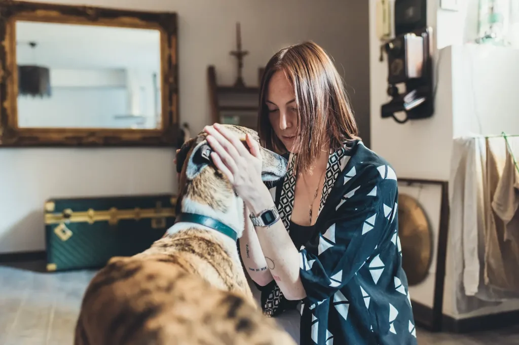 Una mujer acaricia con cariño la cara de su perro